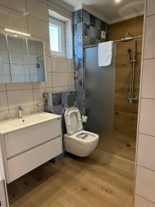 a bathroom with a toilet and a sink and a shower at Aurum Villas Smokinya Beach 2 in Sozopol +7 photos