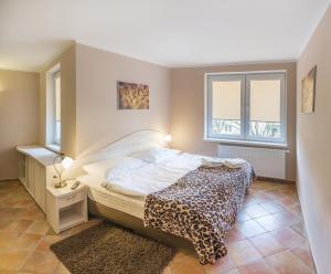 a bedroom with a bed and two windows at Apartamenty Rok in Kołobrzeg