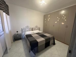 a bedroom with a bed with a black and white at Casa Cioppy in Cala Gonone +5 photos