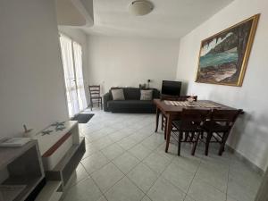 a living room with a table and a couch at Casa Cioppy in Cala Gonone