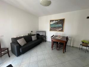 a living room with a black couch and a table at Casa Cioppy in Cala Gonone