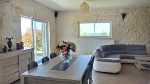 a living room with a table and a couch at Maison spacieuse proche de Saint-Emilion in Ruch