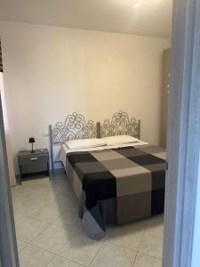 a bedroom with a bed with a black and white blanket at Casa Cioppy in Cala Gonone