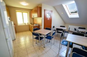 a room with tables and chairs and a kitchen at U Michała in Kielce