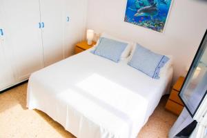 a white bed with blue pillows in a room at Villa Fedora in Haría +17 photos