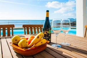 a bowl of fruit on a table with two wine glasses at Villa Fedora in Haría