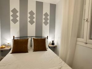 a bedroom with a bed with gray and white stripes at Vintage House, a Traditional Zakynthian Home in central Zante Town by Villa Mana Gers in Zakynthos Town