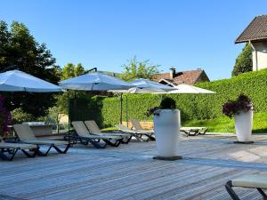 un gruppo di sedie e ombrelloni su un patio di Résidence Les Vallées Labellemontagne a La Bresse Altre 8 foto