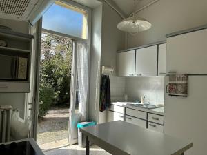 a kitchen with white cabinets and a large window at La maison d'Ulysse in Saint-Hippolyte-de-Caton