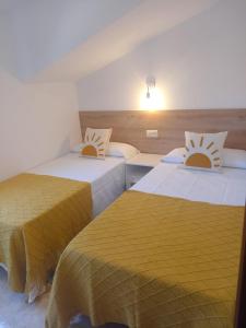 dwa łóżka w pokoju z żółtą pościelą w obiekcie Casa O Vento w mieście O Grove