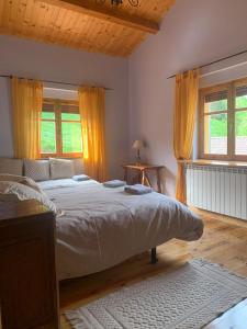 a bedroom with a large bed and two windows at Casa Rural MONTE ROBLO in Salamón