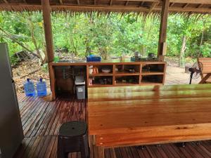 eine Holzterrasse mit einer Bar und einigen Wasserflaschen in der Unterkunft Sunset Surf Hostel Siargao in General Luna