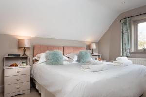 a bedroom with two beds with towels and a window at The Old Bakery Sleeps 4 in Kingham