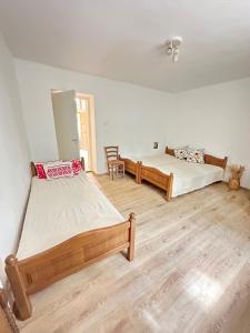 two beds in a room with wooden floors at Templomdomb apartman in Kővágóörs