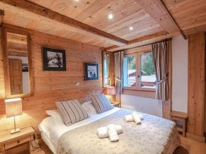 sypialnia z łóżkiem w pokoju z drewnianymi ścianami w obiekcie Charmant appartement près pistes et centre, WiFi, parking privatif - FR-1-343-193 w Chamonix-Mont-Blanc