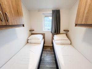 two beds in a small room with a window at Port Nordkapp Mobile House in Skarsvåg