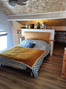 a bedroom with a bed in a room with wooden floors at La Maison Ocre in Mirepeisset