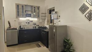 cocina con armarios negros y nevera en Cozy Beachside Stay, en Varca