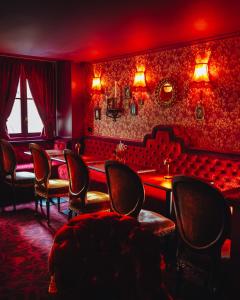a red room with chairs and a table and a tableasteryasteryasteryasteryastery at Madame C - Hôtel Particulier in Strasbourg