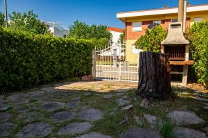a fence and a tree in front of a house at La Casa di Sara in Marcelli