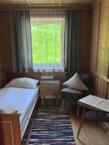 a small bedroom with a bed and a window at Fankhauser Apartments - am Berg in Ried im Zillertal