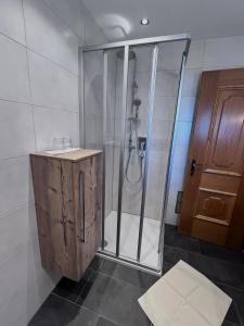 a bathroom with a shower and a wooden cabinet at Fankhauser Apartments - am Berg in Ried im Zillertal