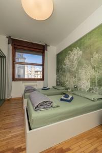 two beds in a room with a painting on the wall at IL Grattacielo Di Genova in Genova