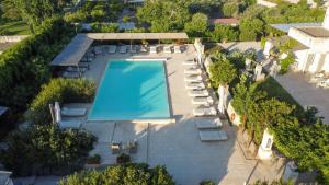 an overhead view of a swimming pool with chairs and trees at Masseria Borgo Sentinella in Torre dell'Orso