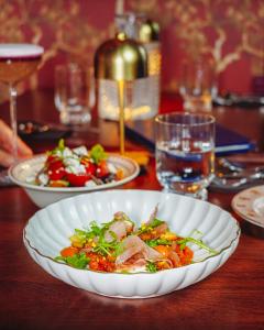 a table with a plate of food on a table at Madame C - Hôtel Particulier in Strasbourg
