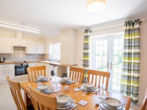 a kitchen with a wooden table with chairs and a dining room at Dawson Park 8 - Uk12667 in Mablethorpe