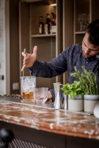 a man standing at a counter stirring a drink at No 42 by GuestHouse, Margate in Margate