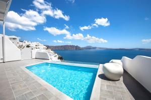 a swimming pool with a view of the water at Santorini Secret Suites & Spa, Small Luxury Hotels of the World in Oia