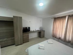 巴克乌Riz camera的客房设有一张床、一张书桌和电视