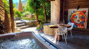 een terras met een tafel en een schilderij van een beer aan de muur bij La Bergerie du Miravidi in Bourg-Saint-Maurice