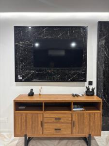 a entertainment center with a large television on a wall at Casa do Cachucho in Horta