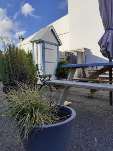 a picnic table and a bench in front of a building at Les Chambres de Kérity in Penmarch