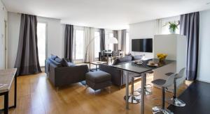 Una sala de estar con un sofá, una mesa y sillas. en Durlet Beach Apartments, en Barcelona