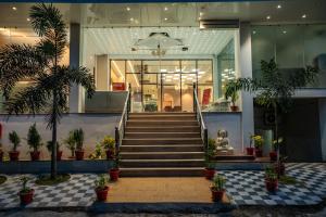 a lobby of a building with stairs and potted plants at Evara Inn in Varanasi