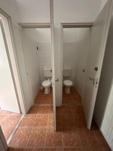 a bathroom with two toilets and two stalls at Stúdió apartman in Kővágóörs