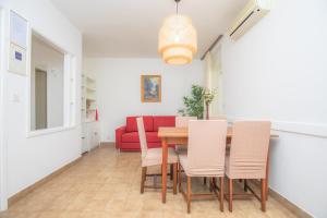 una sala da pranzo con tavolo e divano rosso di Feel the sea a Primošten