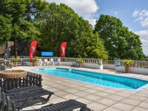 a swimming pool with two chairs and a table at Honey Lodge in Gunnislake