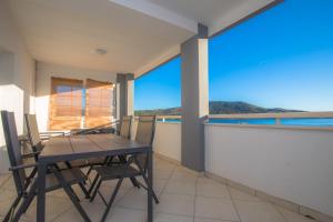 un tavolo e sedie su un balcone con vista sull'oceano di Feel the sea a Primošten Altre 12 foto