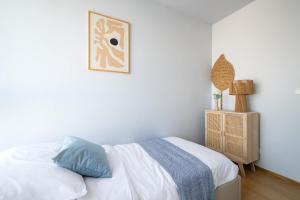 グダニスクにあるElite Apartments Beachside Luxury with Balconyのベッドと壁に絵が飾られた寝室