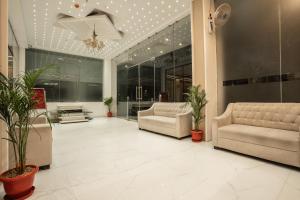a lobby with two couches and potted plants at Evara Inn in Varanasi