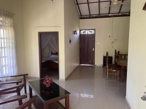 Una sala de estar con una mesa y un dormitorio. en Three Brothers Villa, en Mirissa