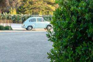 a small blue car parked in a parking lot at Masseria Borgo Sentinella in Torre dell'Orso