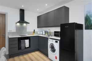 マトロックにある1 Bed Flat in Central Matlock Near Top Attractionsのキッチン(黒い冷蔵庫、洗濯機付) +5枚の写真