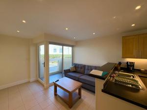 a kitchen and a living room with a couch at West Beach - Holiday Apartments in Westward Ho