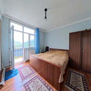 a bedroom with a bed and a large window at Skyline Mestia in Mestia +39 photos