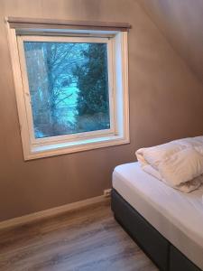 a bedroom with a bed and a window at Small farm in Bjørheimsbygd, 30 min from Preikestolen in Strand